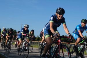 A group of cyclists riding down a road.